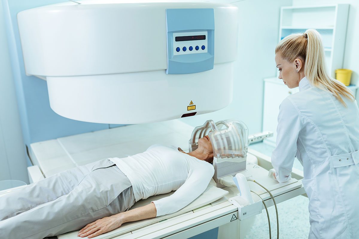 Medical technician preparing a patient for MRI brain scan in the